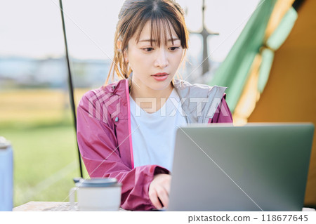 A woman working remotely at a campsite 118677645