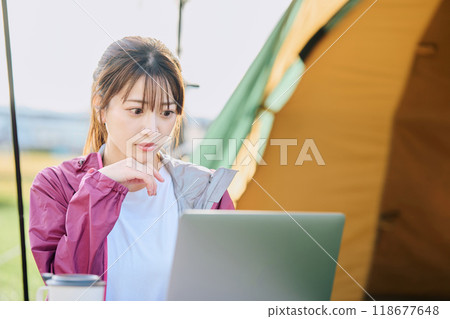 A woman working remotely at a campsite 118677648