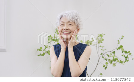 Elderly woman doing facial care at home, looking at camera 118677842