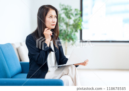 Middle-aged businesswoman working in an office Middle-aged businesswoman working in an office 118678585