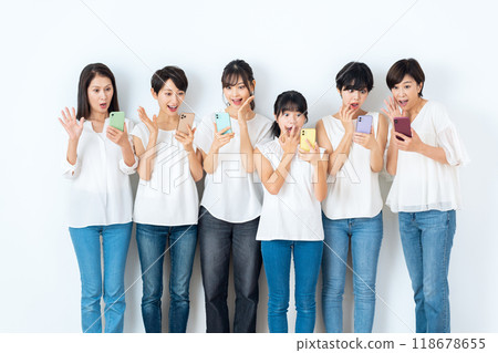 Multi-generational women looking at smartphones 118678655