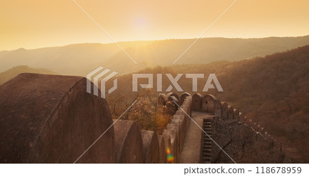 Jaipur, Rajasthan, India. Fortress Wall Surrounding Amer Fort Or Amber Fort, Amer Situated On Forested Hill. Bright Sunset Sky. Great Example Of Rajput Architecture. Popular Tourist Attraction In 118678959