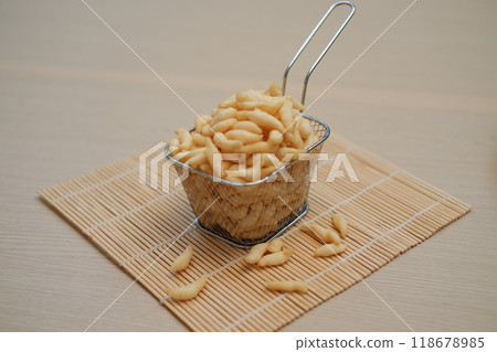 telur gabus sticks in a metal basket on wooden table telur gabus sticks in a metal basket on wooden table 118678985