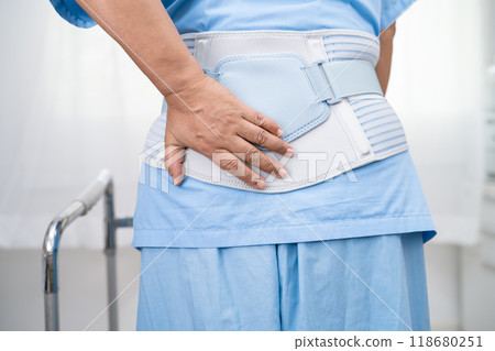 Asian lady patient wearing back pain support belt for orthopedic lumbar with walker. 118680251