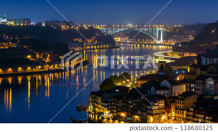 City of Porto and Gaia at night by the Douro river timelapse in Portugal, Arrabida Bridge at the far end. 118680325
