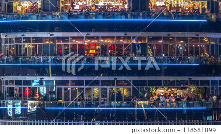 Circular building with different restaurants at each floor in the heart of Dubai Marina district night timelapse. Circular building with different restaurants at each floor in the heart of Dubai Marina district night timelapse. 118681099