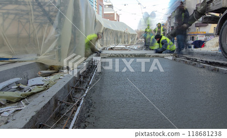 Pouring ready-mixed concrete after placing steel reinforcement to make the road by concrete mixer timelapse hyperlapse. 118681238