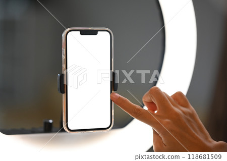 Close up shot woman setting up a smartphone on a ring light for video recording or live streaming 118681509