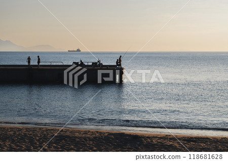 Silhouettes of male fishermen fishing on pier in the sea in the evening Silhouettes of male fishermen fishing on pier in the sea in the evening 118681628