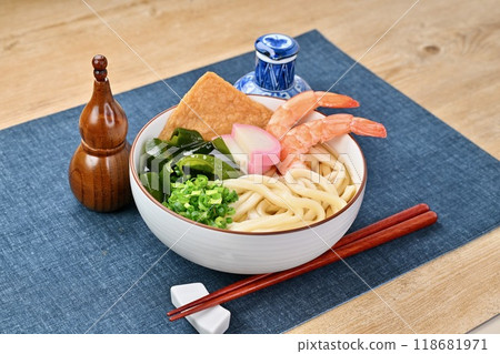 Cold udon noodles, cold udon noodles in soup, shrimp, fried tofu, kamaboko, seaweed, and green onions. 118681971