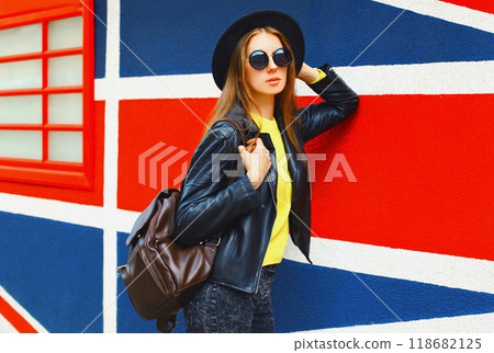 Portrait of beautiful young woman posing on english flag wall background 118682125
