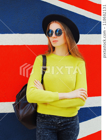 Portrait of beautiful young woman posing on english flag wall background Portrait of beautiful young woman posing on english flag wall background 118682131