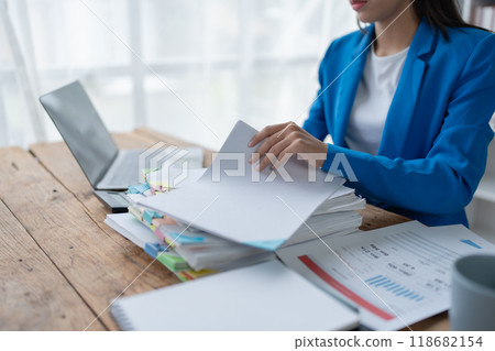 woman plans a finance and budget audit by reviewing organizing office financial documents woman plans a finance and budget audit by reviewing organizing office financial documents 118682154