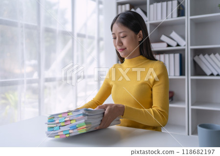 woman plans a finance and budget audit by reviewing organizing office financial documents 118682197