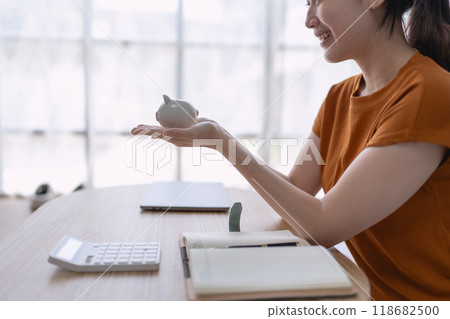woman carefully develops a financial saving plan, organizing her resources to achieve long-term financial security and stability 118682500