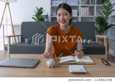woman financial saving plan in a notebook, organizing her goals and budgeting strategies to achieve long-term financial stability and success 118682506