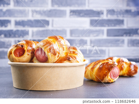 Close-up of baked sausages in dough in bowl. Close-up of baked sausages in dough in bowl. 118682646