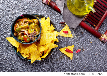 Single big black plate of yellow corn tortilla nachos chips with salsa sauce 118682659