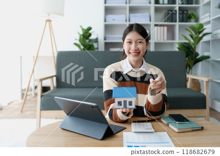 woman holds the key to her new house, securing a loan to manage the financial aspects of her home ownership, balancing finance and the responsibilities of a housing loan woman holds the key to her new house, securing a loan to manage the financial aspects of her home ownership, balancing finance and the responsibilities of a housing loan 118682679