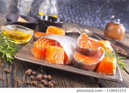 Salmon. Fresh raw salmon fish fillet with cooking ingredients, herbs and lemon on dark background 118683153