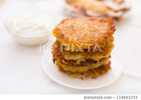 Potato pancakes with sour cream on white plate 118683255