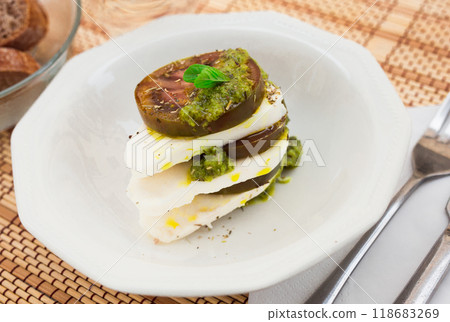 Caprese salad with mozzarella, black tomatoes and pesto in white plate Caprese salad with mozzarella, black tomatoes and pesto in white plate 118683269