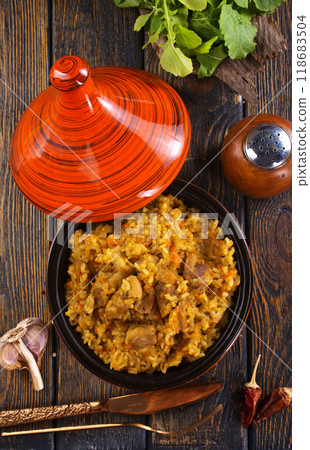 Uzbek cuisine food pilaf, rice with carrots, vegetable oil, raisins 118683504