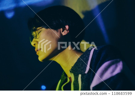 Profile of a young man closing his eyes listening to music 118683599