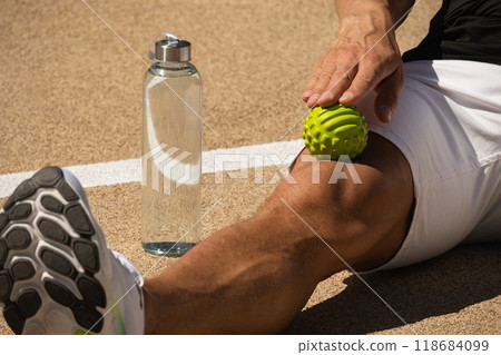 Athletes man is massaging his leg by massage ball techniques for tense after active workout 118684099