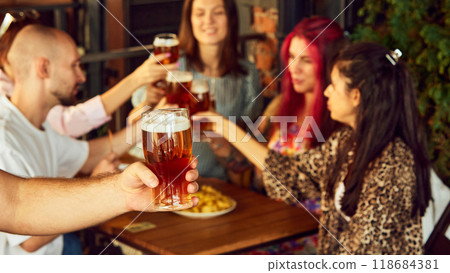 Glasses raised high, fans immerse themselves in energy of game, savoring every sip and every moment. Selective focus. Glasses raised high, fans immerse themselves in energy of game, savoring every sip and every moment. Selective focus. 118684381