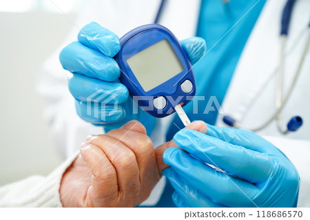 Asian doctor using digital glucose meter for check sample blood sugar level to treatment diabetes. Asian doctor using digital glucose meter for check sample blood sugar level to treatment diabetes. 118686570