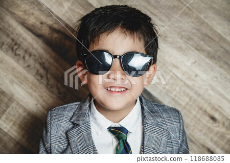 A child in a suit wearing sunglasses A child in a suit wearing sunglasses 118688085