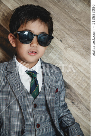 A child in a suit wearing sunglasses 118688086