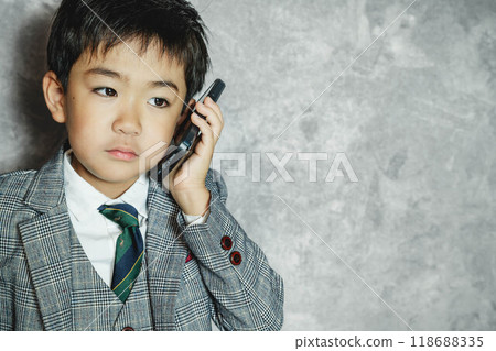 穿著西裝的孩子操作智慧型手機 118688335