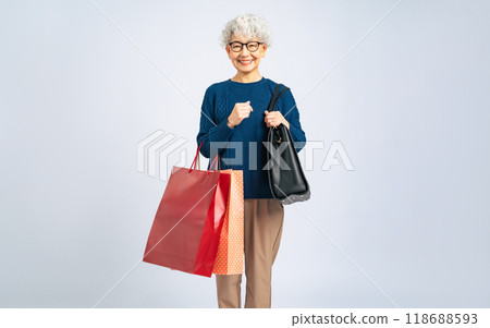 Full body photo of a senior woman carrying a shopping bag 118688593