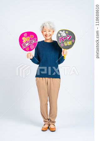 Full-body photo of a senior woman holding a fan Full-body photo of a senior woman holding a fan 118688610