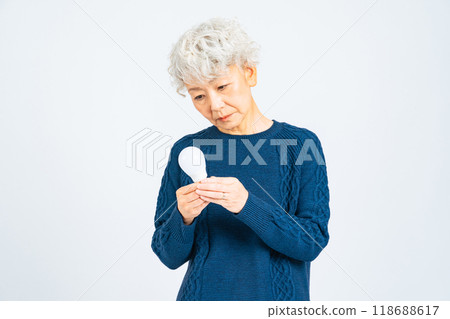 Senior woman looking at a light bulb 118688617