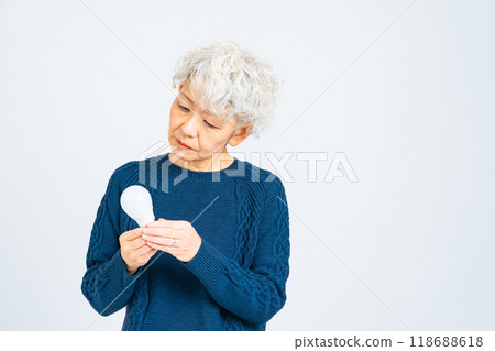 Senior woman looking at a light bulb 118688618