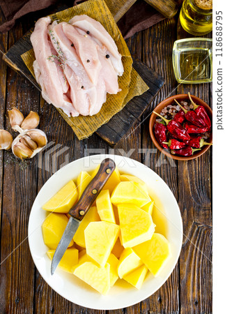 raw potato and chicken on wooden table 118688795