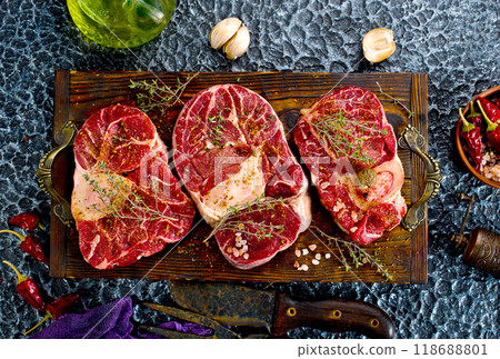 A few steak pieces on the wooden board on a table 118688801