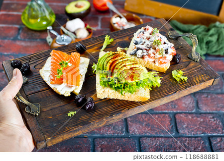 Open sandwiches with salted salmon, guacamole avocado and microgreens. Open sandwiches with salted salmon, guacamole avocado and microgreens. 118688881