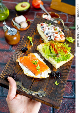 Open sandwiches with salted salmon, guacamole avocado and microgreens. Open sandwiches with salted salmon, guacamole avocado and microgreens. 118688882