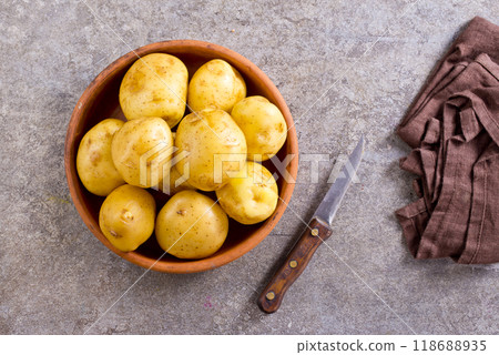 bowl with raw potatoes on a table bowl with raw potatoes on a table 118688935