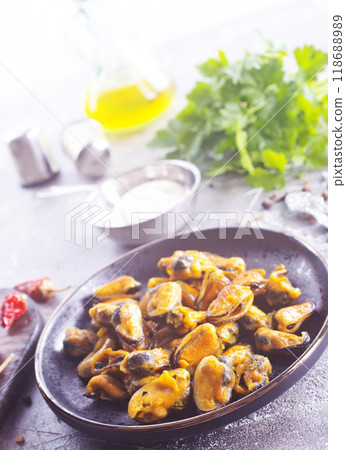 spicy stir fried mussel with slice onion and spice on plate 118688989