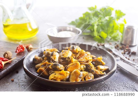 spicy stir fried mussel with slice onion and spice on plate 118688990