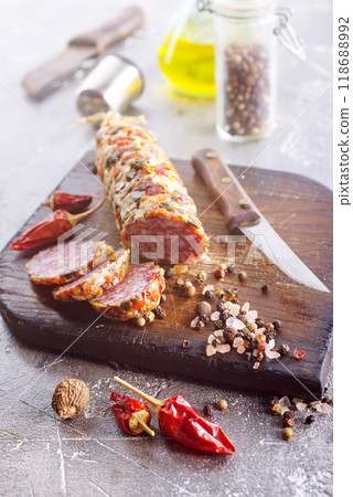 Traditional smoked salami sausage on wooden board. Slices of sausage in motion. 118688992