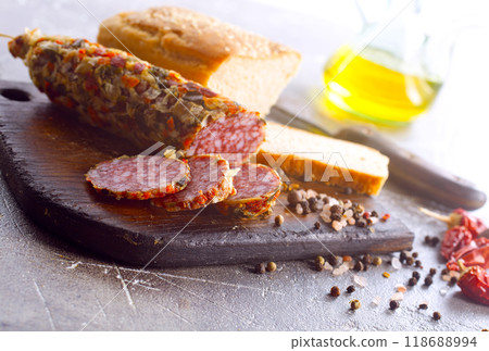 Traditional smoked salami sausage on wooden board. Slices of sausage in motion. 118688994