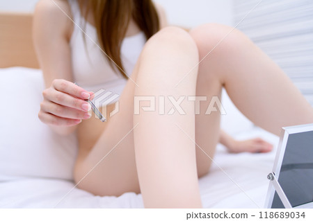 VIO：一位年輕女子一邊照鏡子，一邊用鑷子拔出鑷子。 118689034