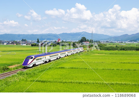 [Yamagata Line] A mini Shinkansen train running through a rural landscape 118689068