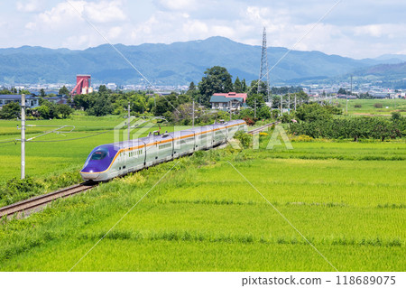 [Yamagata Line] A mini Shinkansen train running through a rural landscape 118689075